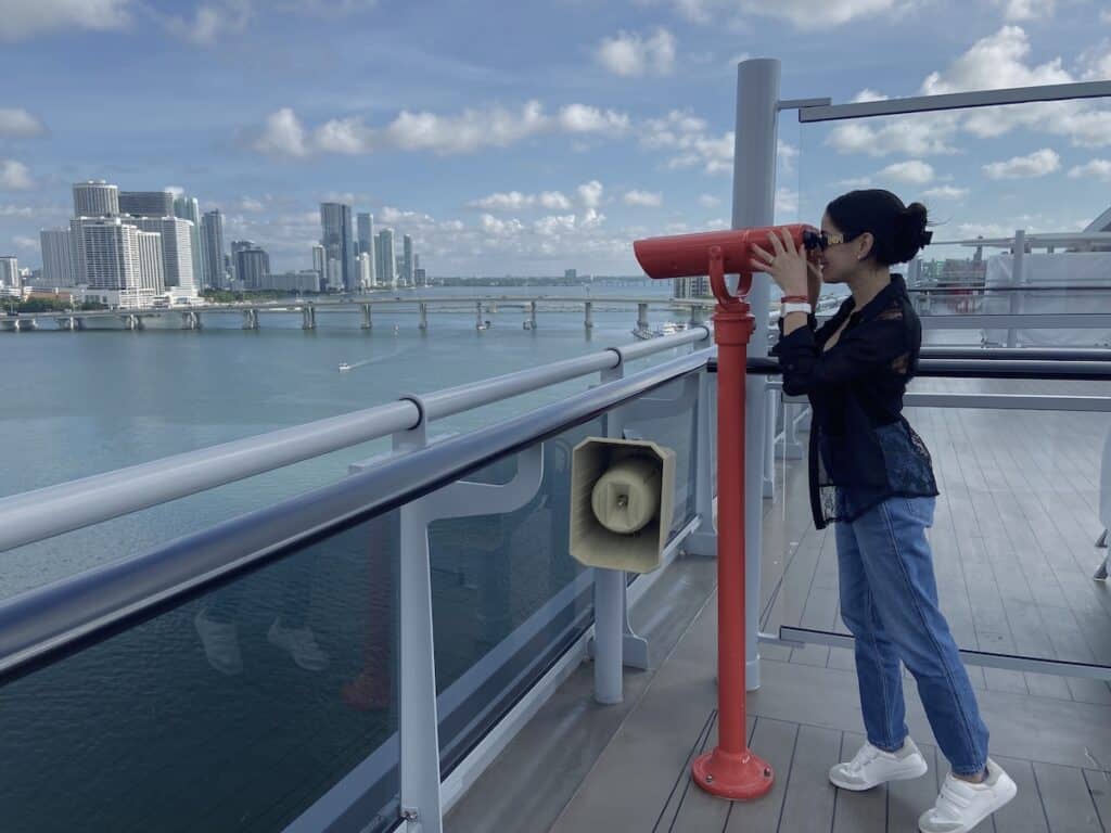Using binoculars which is one of the instagrammable Spots on virgin voyages