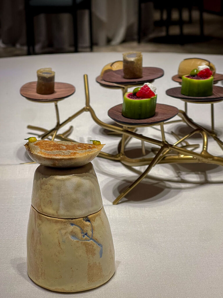 different small dishes like a zucchini filled with beets, a roasted onion which are some of the vegan options in Ricard Camarena Restaurant in Valencia