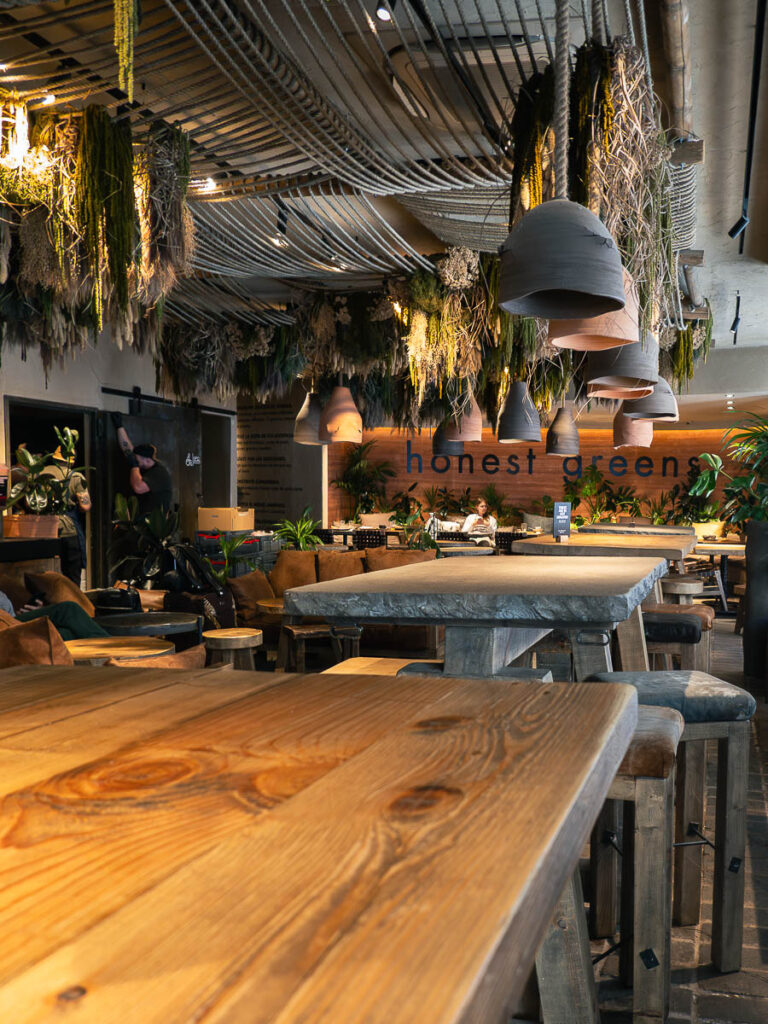 interior of Honest Green a Valencia vegan restaurant filled with tables and hanging lamps