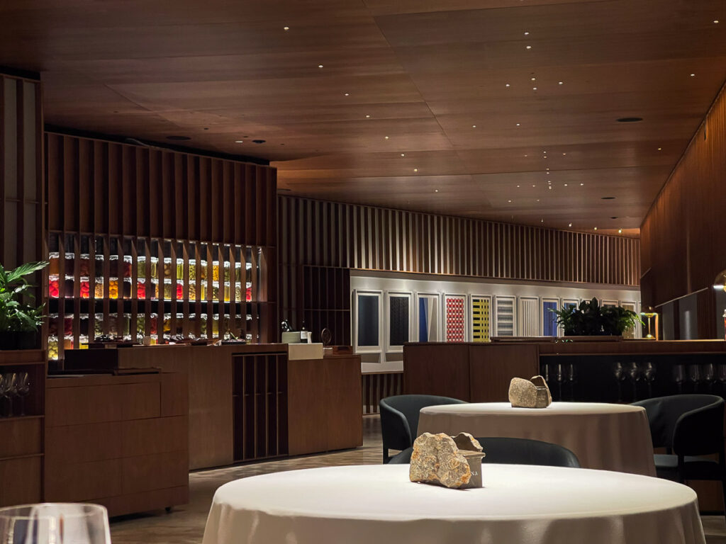 circular tables with white table cloth and modern wooden walls which is the place of the best vegan Valencia dining experience at Ricard Camarena