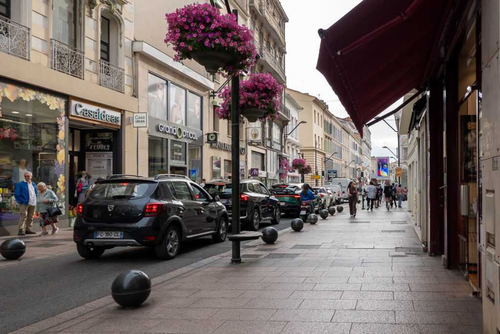 a street with cars and stores for shopping which is one of the what to do in cannes from the cruise ship port