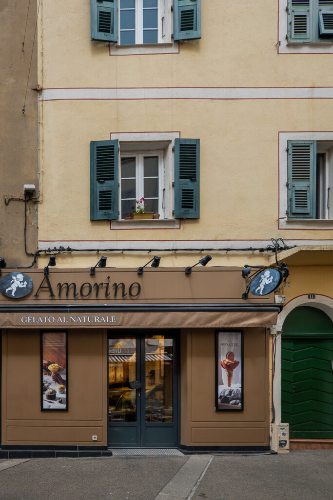 brown and yellow building with green windows which is the entrance of Armorino Gelato al Naturale which has vegan ice cream options in Ajaccio Corsica cruise port