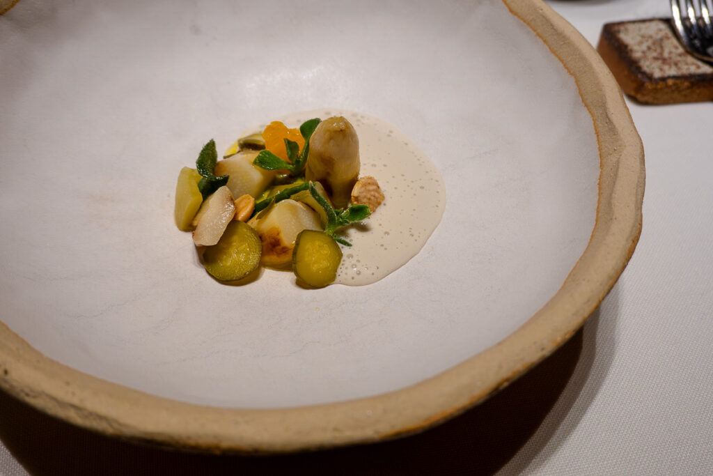 white asparagus veloute with almonds and fresh herbs a plate of a Michelin star fine dining in Valencia Spain