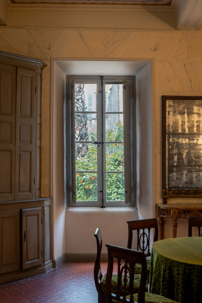 a window and a dining table which are the interior of the Napoleons birthplace house museum in Ajaccio Corsica