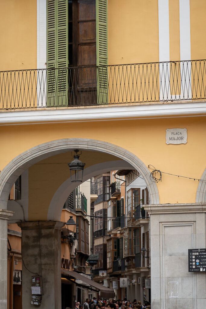 yellow structure with an arch entrance and the sign of Palma de Mallorca plaza major
