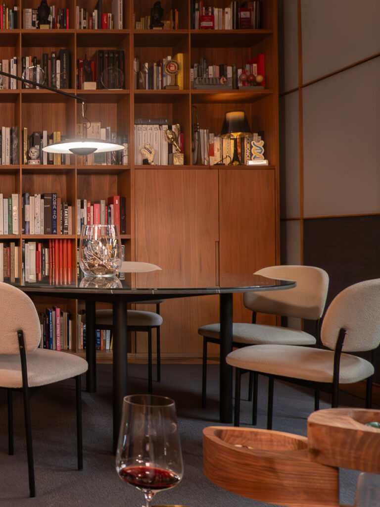 dining able and white chairs with a bookshelf in the background wall which is the dessert area in the Ricard Camarena Valencia