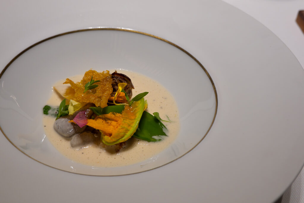 greens and edible flowers in a delicious white cream soup from the upscale Michelin star vegan experience in Valencia Spain