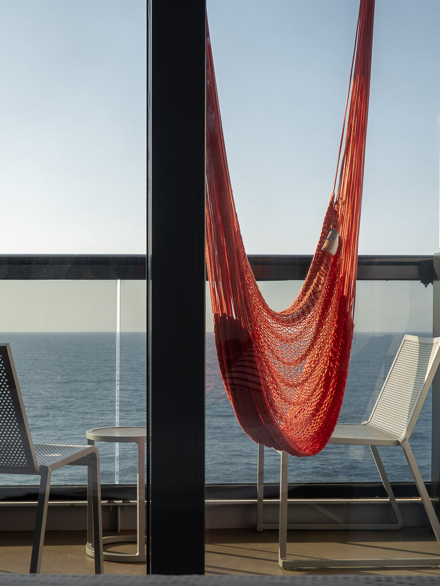 Sea Terrace cabin on Virgin Voyages, red hammock on the balcony while sailing the Virgin Voyages Mediterranean itinerary