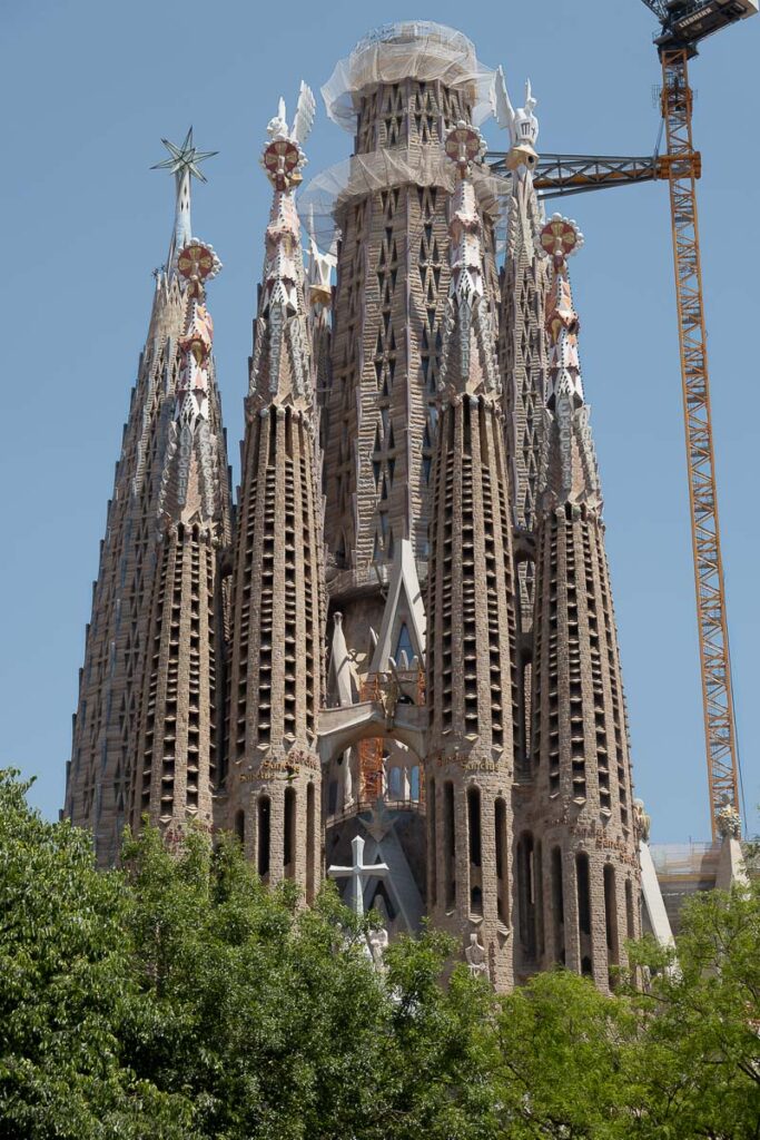 an exterior religious structure with a crane which is the Barcelona La Sagrada Familia in Barcelona