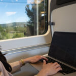 woman typing in laptop in the valencia spain high speed train learning to become a blogger