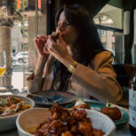 a female eating in wildfood barcelona vegan guides