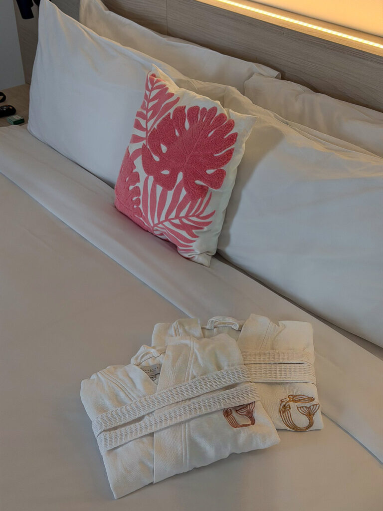 comfortable bedroom with white robes on top in the greystone hotel in miami which is the best place to stay in miami for young adults