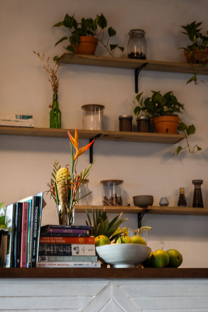 a wall with shelves and plants which represents the interior of berlingeri cocina artesanal in san juan