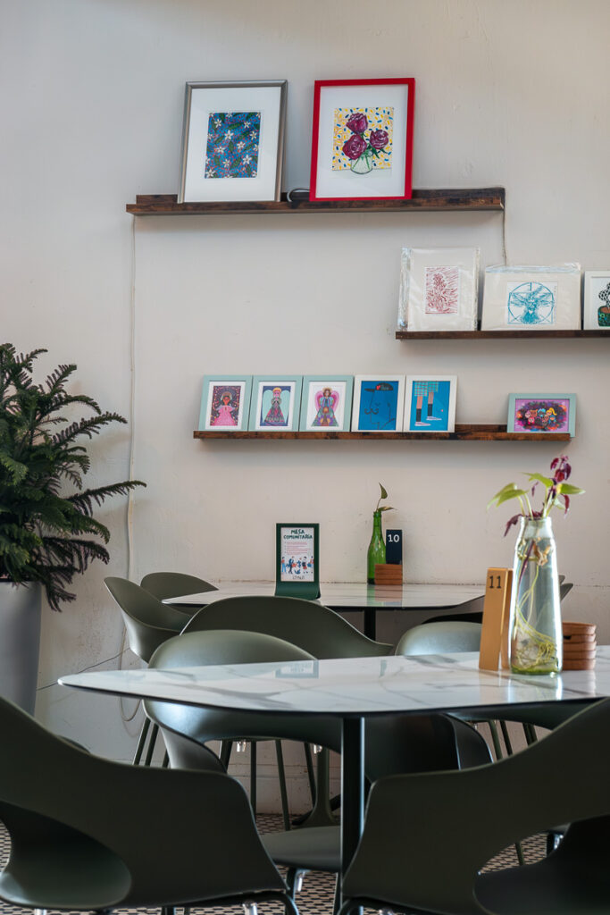 chair and table and a wall with frames which represents the interior of la isla restaurant in san juan