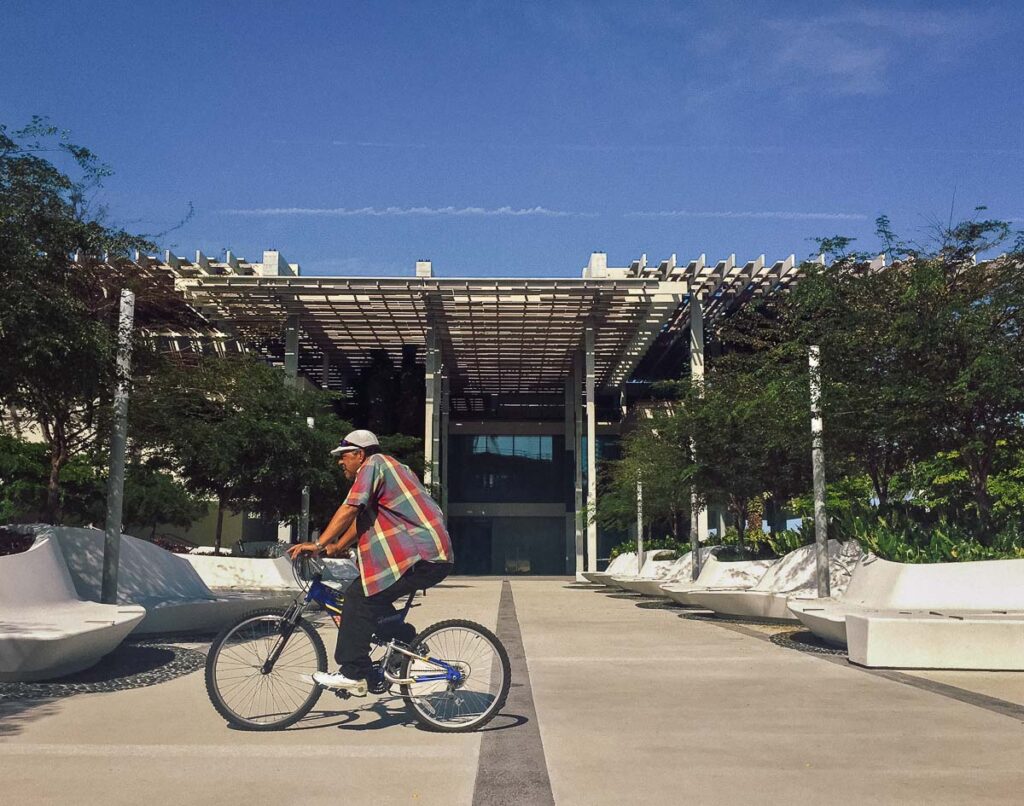a person riding bicycle in front of perez art museum miami