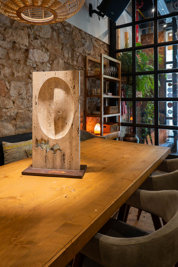 stone wall, wood table and chairs which represents he best vegan fine dining in Barcelona the Xavier Pellicer restaurant