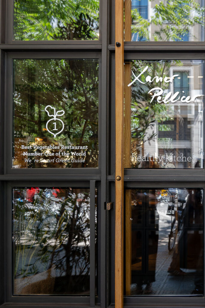 a black and glass door which represents Xavier Pellicer restaurant a top places to eat in Barcelona and the best vegetables restaurant number one of the world 