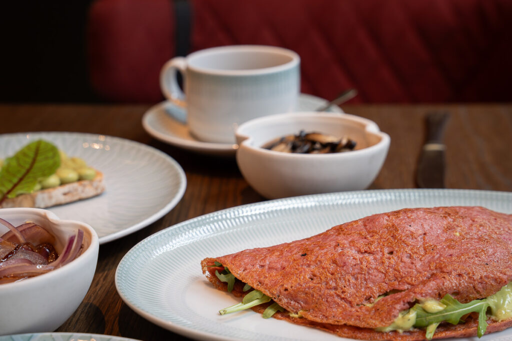 Beetroot crepe with avocado, tomato, and arugula from Art Legacy hotel breakfast plant based option