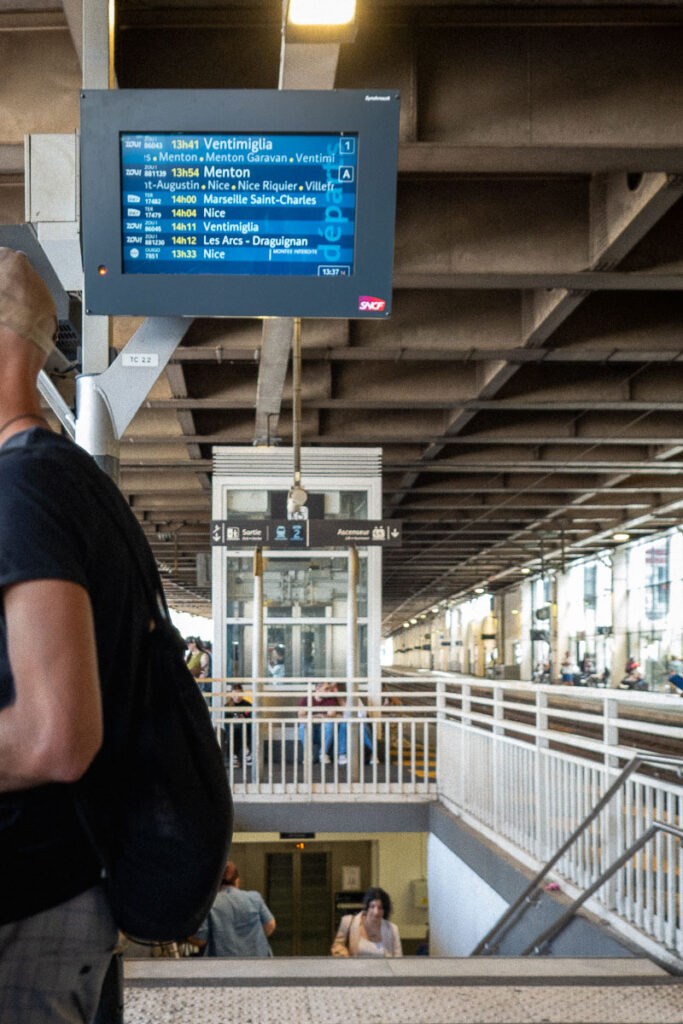 tv screens at the Cannes train station and showing the train stops which represents how far is Monaco from Cannes